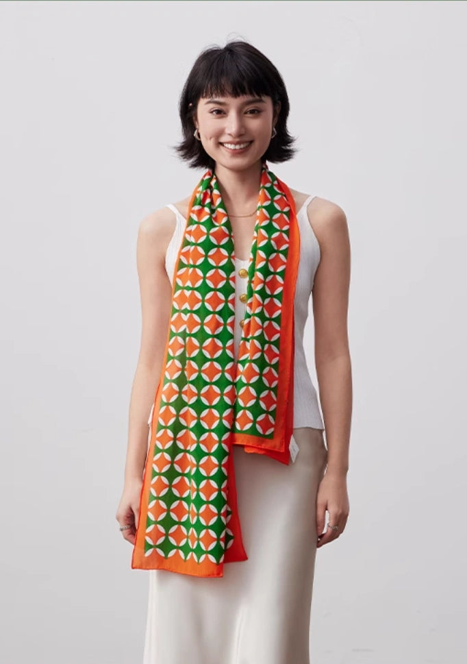 Orange green long silk scarf styled with a white sleeveless dress