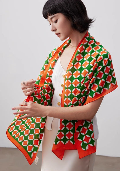 Orange green geometric long silk scarf draped over the shoulders