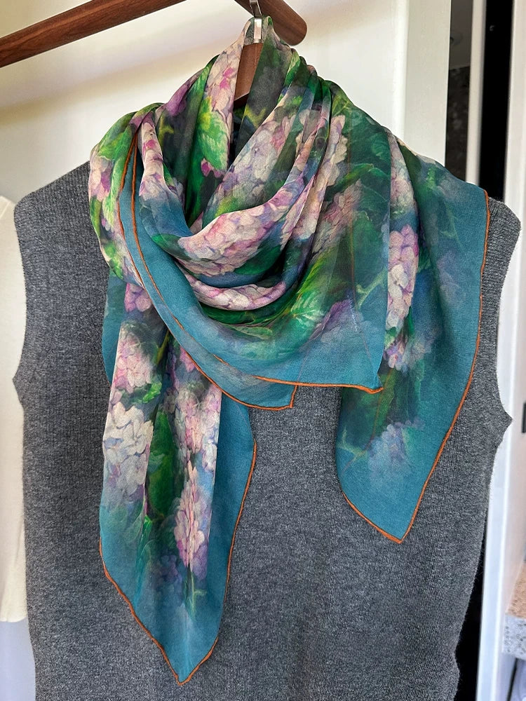 Plant-dyed floral silk square scarf draped over a grey top