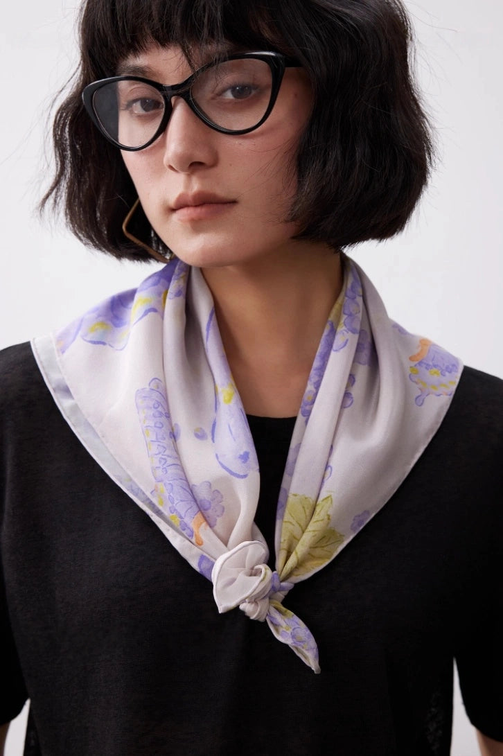 Purple butterfly silk square scarf tied as a neck scarf with a black top