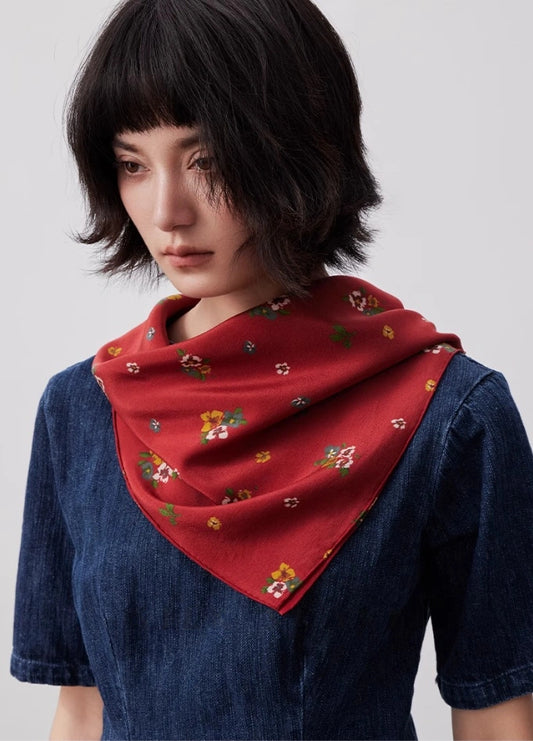 Red floral silk square scarf styled as a neck accessory, demonstrating its elegance and versatility.