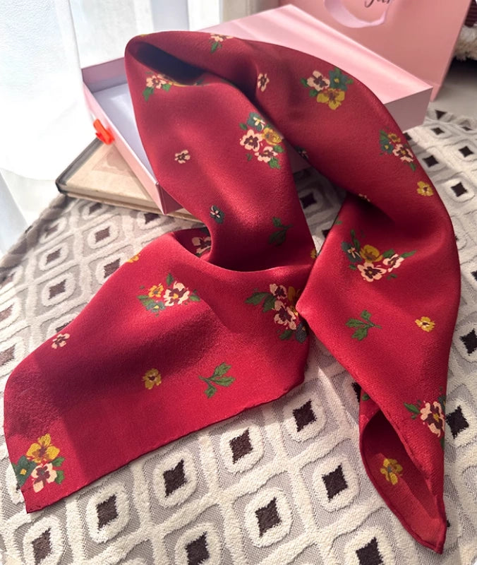 Close-up of red floral silk scarf, showcasing the intricate floral pattern and luxurious texture.