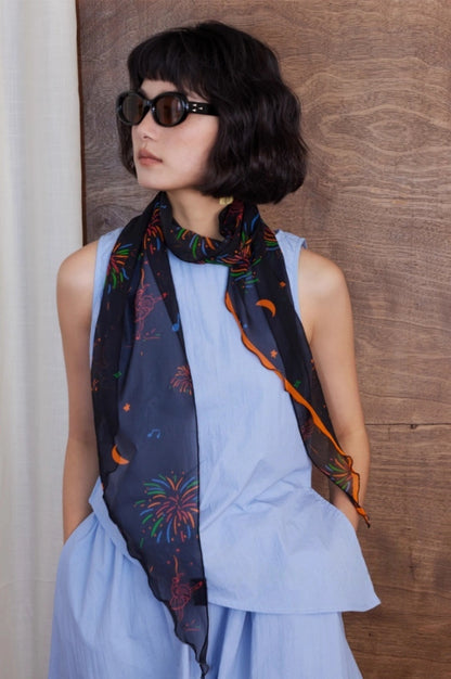 Black fireworks skinny silk scarf worn loosely around the neck for an elegant everyday outfit