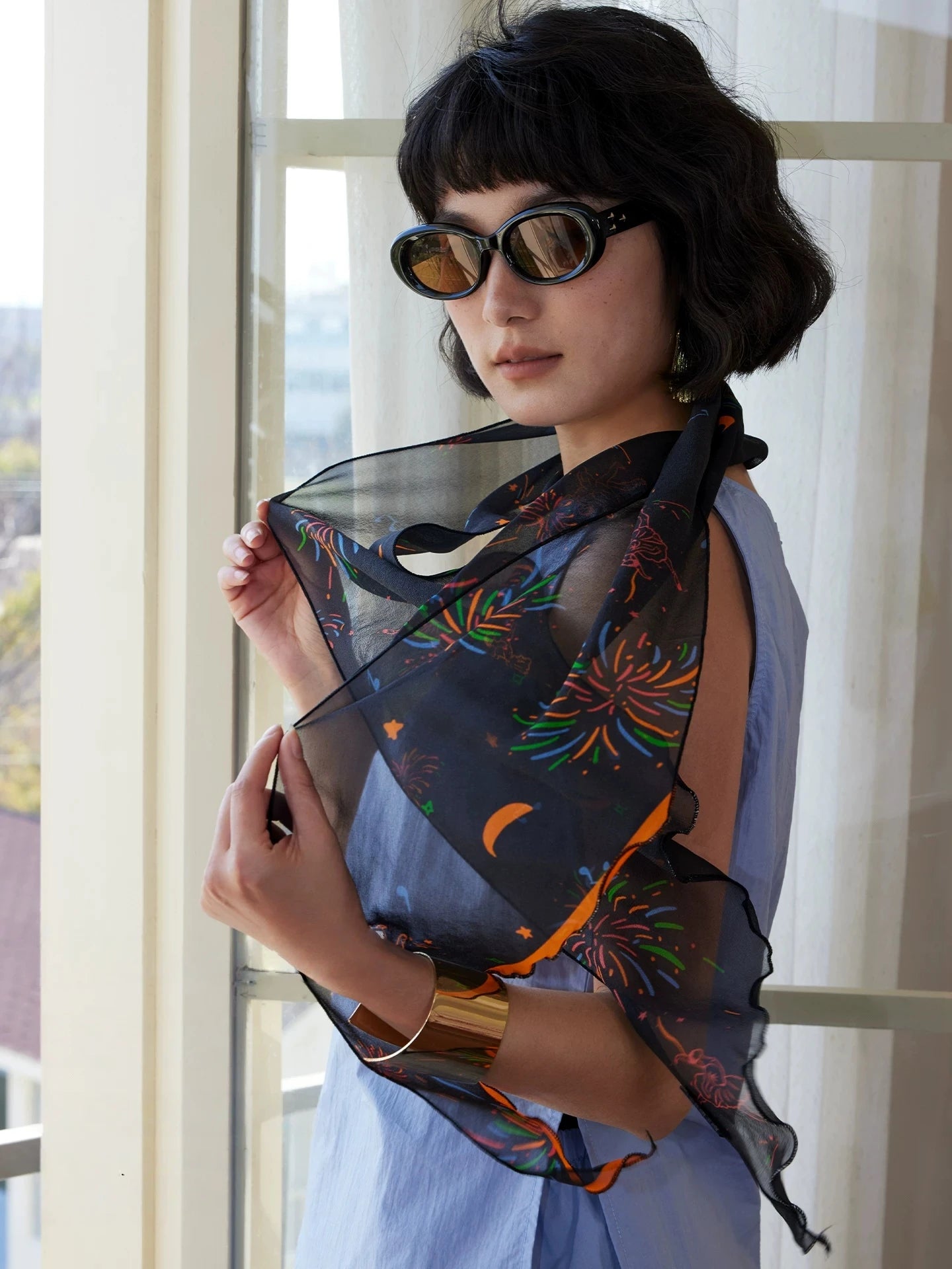 Black mulberry silk skinny scarf with colorful fireworks print styled as a sheer silk wrap