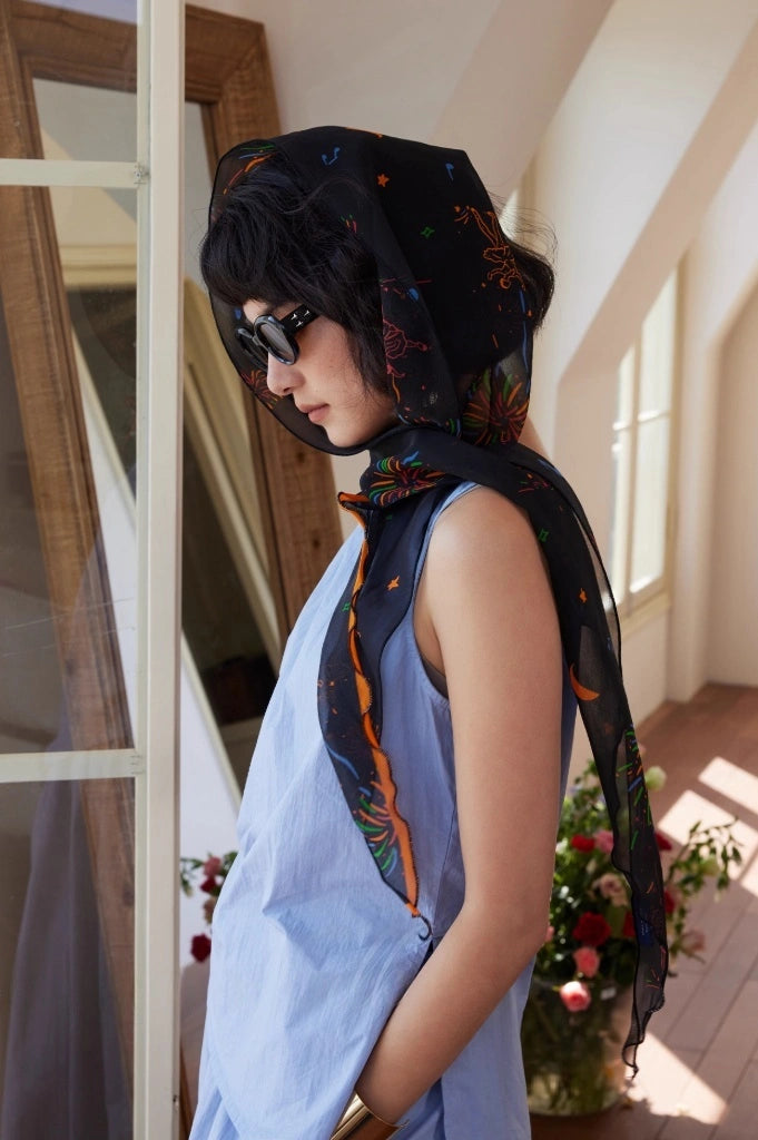 Black fireworks skinny silk scarf worn as a chic headscarf and lightweight neck accessory