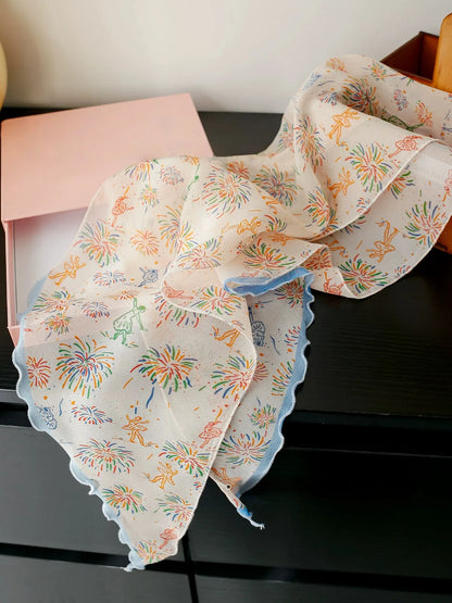 White fireworks mulberry silk skinny scarf displayed flat to show its delicate print and sheer georgette texture