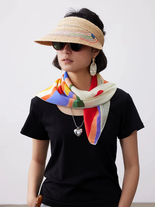 Model wearing a 100% mulberry silk square scarf with abstract sunset mountain print as an elegant silk neckerchief