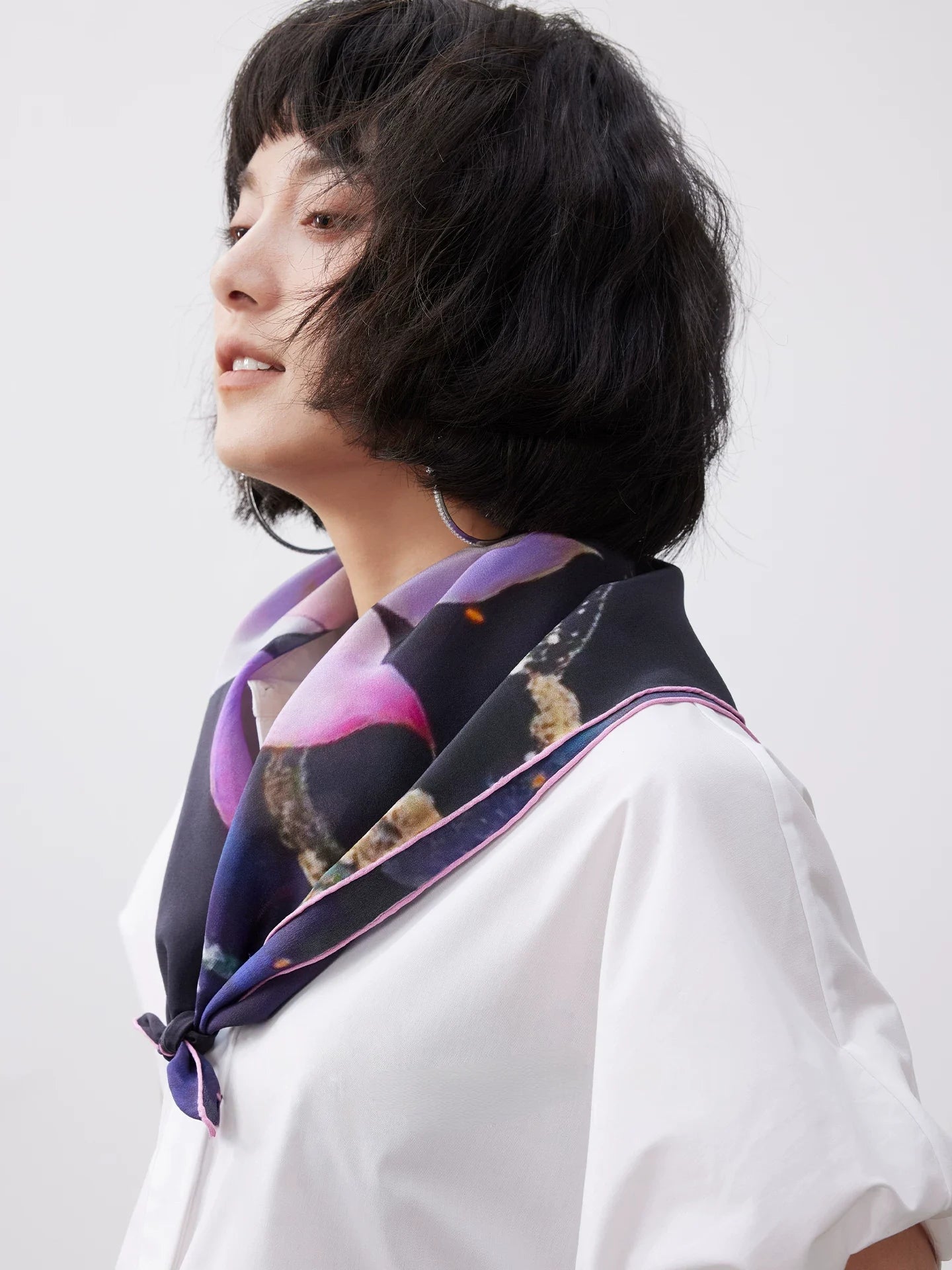 Side view of model wearing lotus print mulberry silk scarf, styled as a refined neck accessory