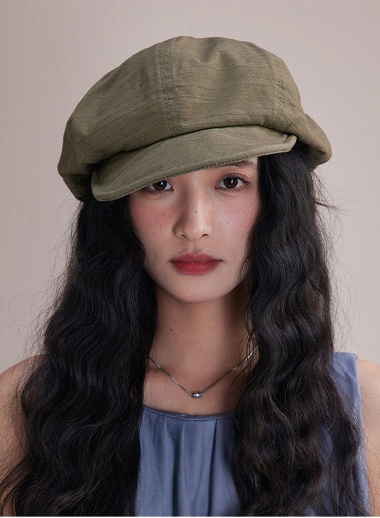 Model wearing bean green slouchy cotton beret hat, a lightweight cotton beret for effortless streetwear style