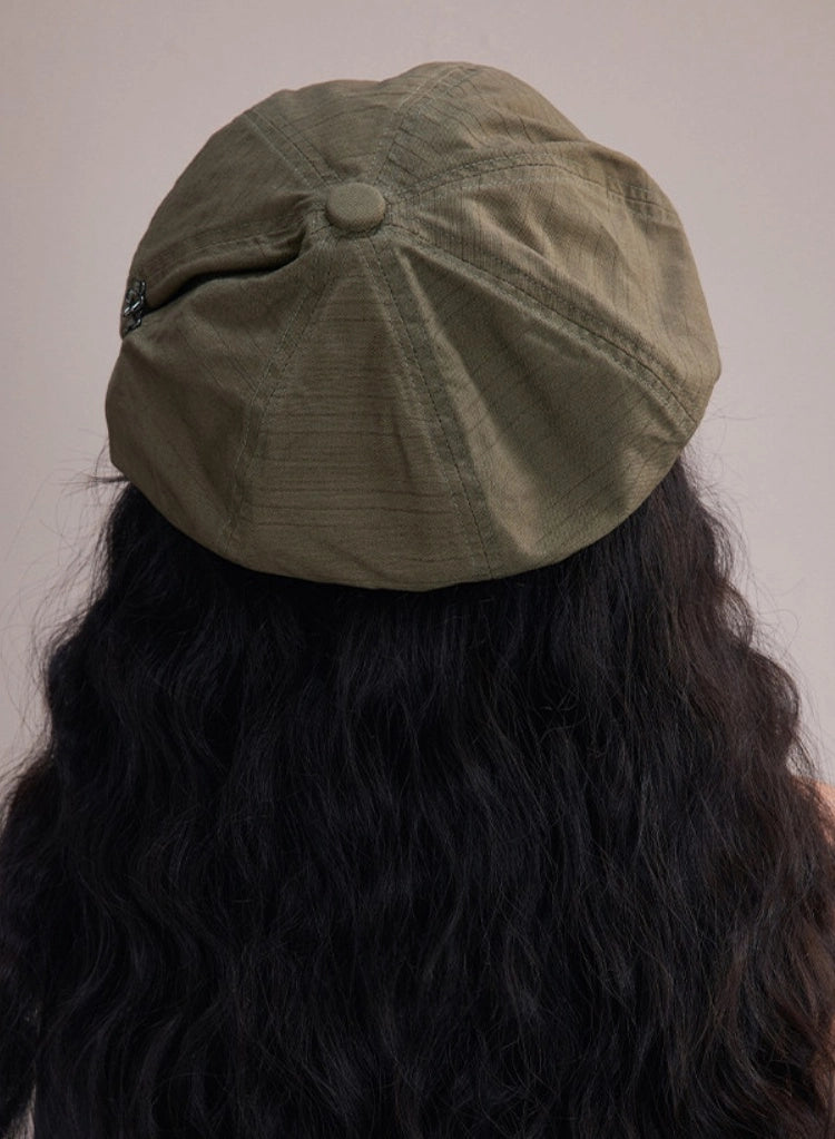 Back view of bean green slouchy cotton beret cap with soft gathered shape and relaxed casual silhouette