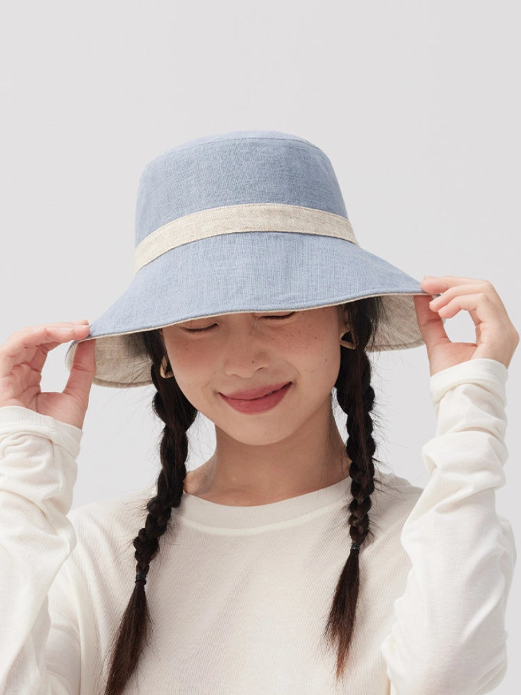 Front view of a model wearing a foldable beige blue embroidered bucket hat