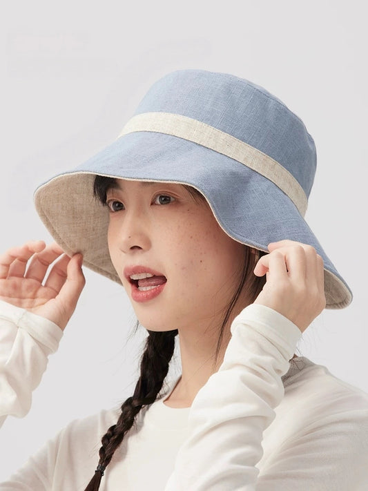 Side view of a beige blue reversible sun hat with contrast trim and curved brim