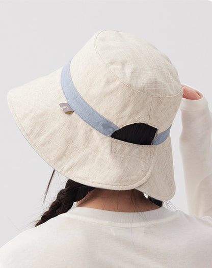 Back view of a beige reversible ramie cotton bucket hat with blue trim and adjustable strap