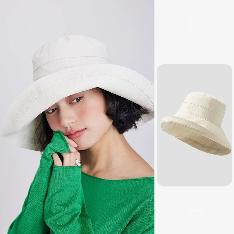 Woman wearing a beige linen blend wide brim sun hat with a softly structured bucket-style silhouette.