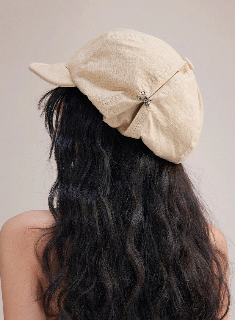 Back view of beige slouchy cotton beret cap with relaxed gathered shape and soft cotton texture
