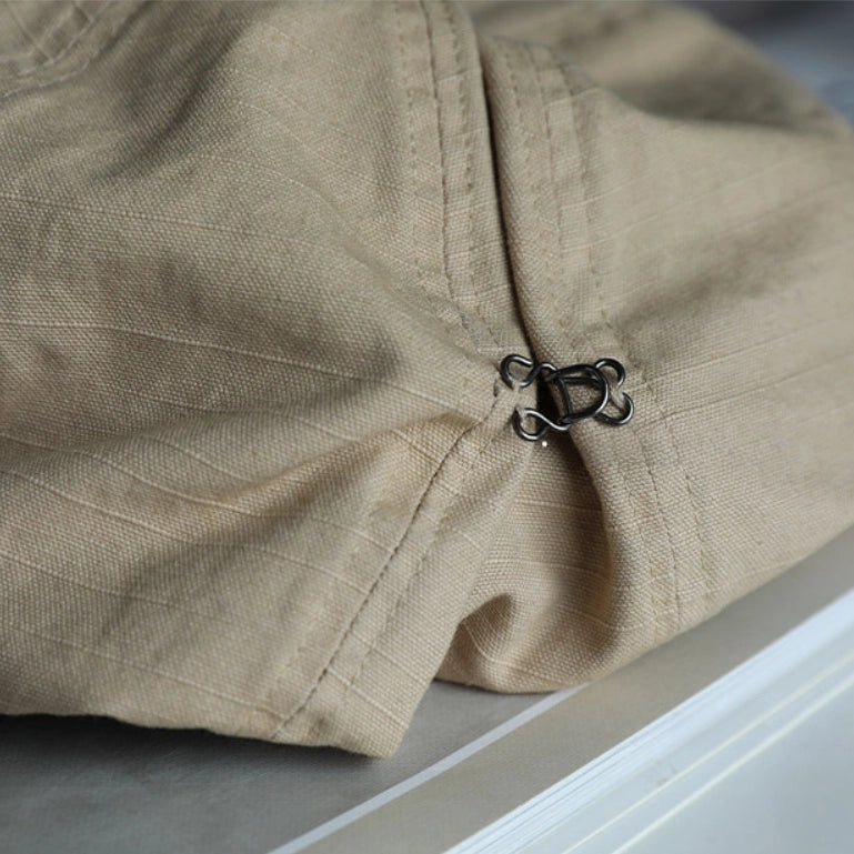 Close-up of beige slouchy cotton beret showing adjustable elastic detail, soft stitching, and cotton texture