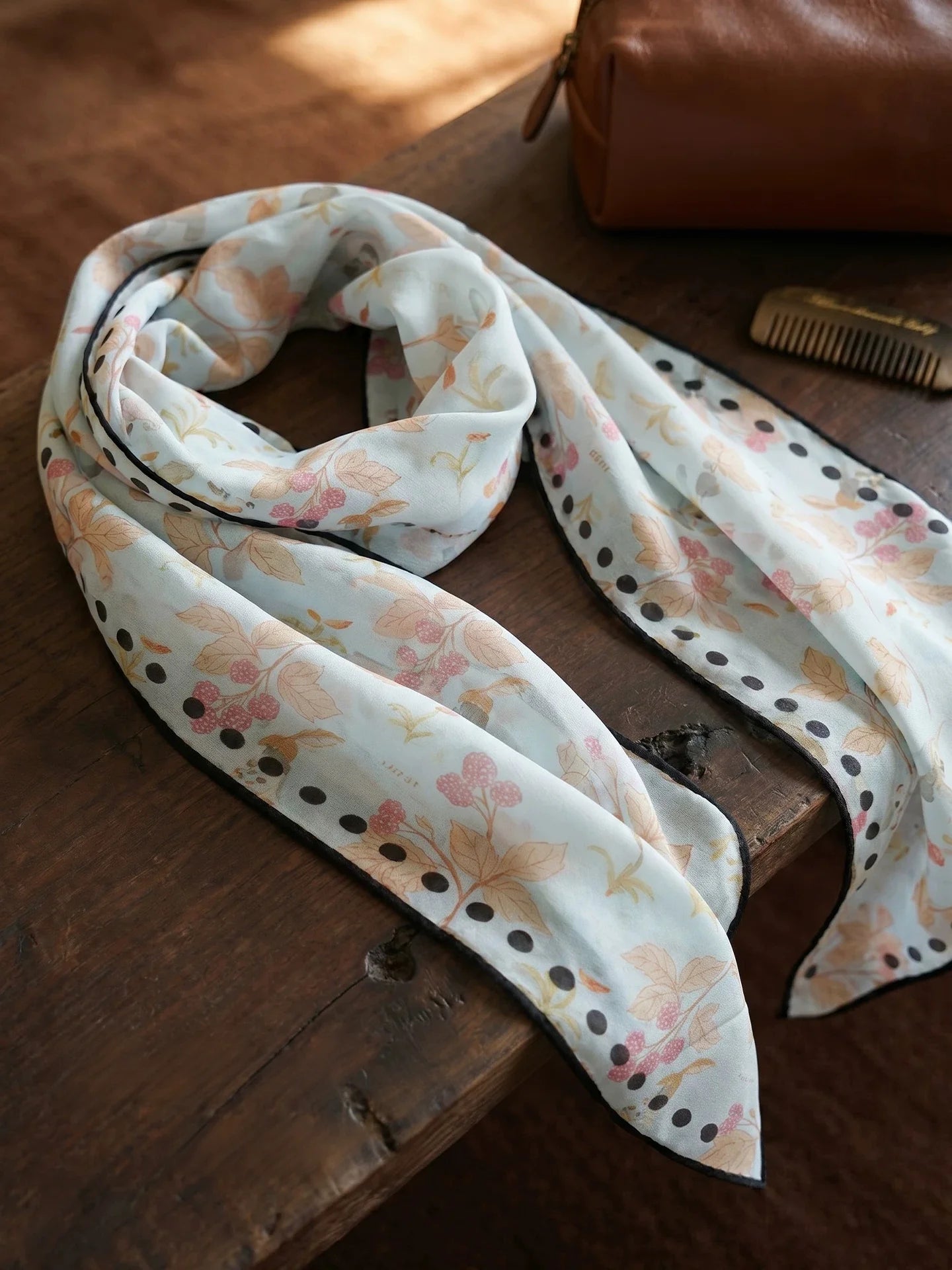 Sky blue berry rabbit print mulberry silk scarf loosely looped on a wooden table