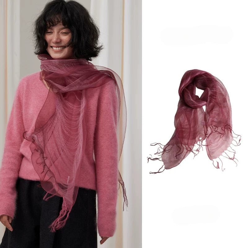 Woman wearing a berry sheer mulberry silk fringe scarf with a pink sweater
