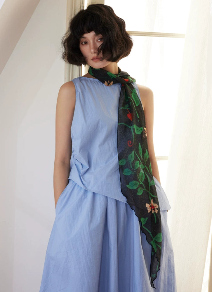Model wearing black botanical silk georgette skinny scarf with blue dress