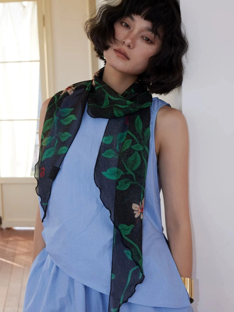 Black botanical mulberry silk scarf tied softly around the neck