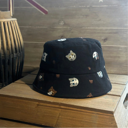Front view of a black cotton cat bucket hat with a short downward brim