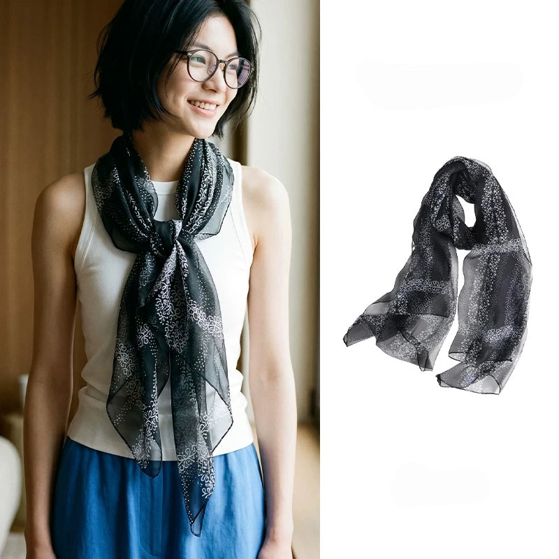 Woman wearing a sheer black floral mulberry silk chiffon scarf beside a full product view