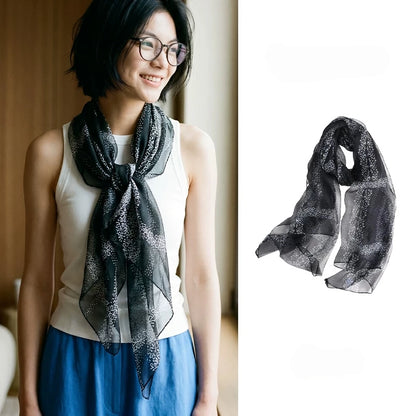 Woman wearing a sheer black floral mulberry silk chiffon scarf beside a full product view