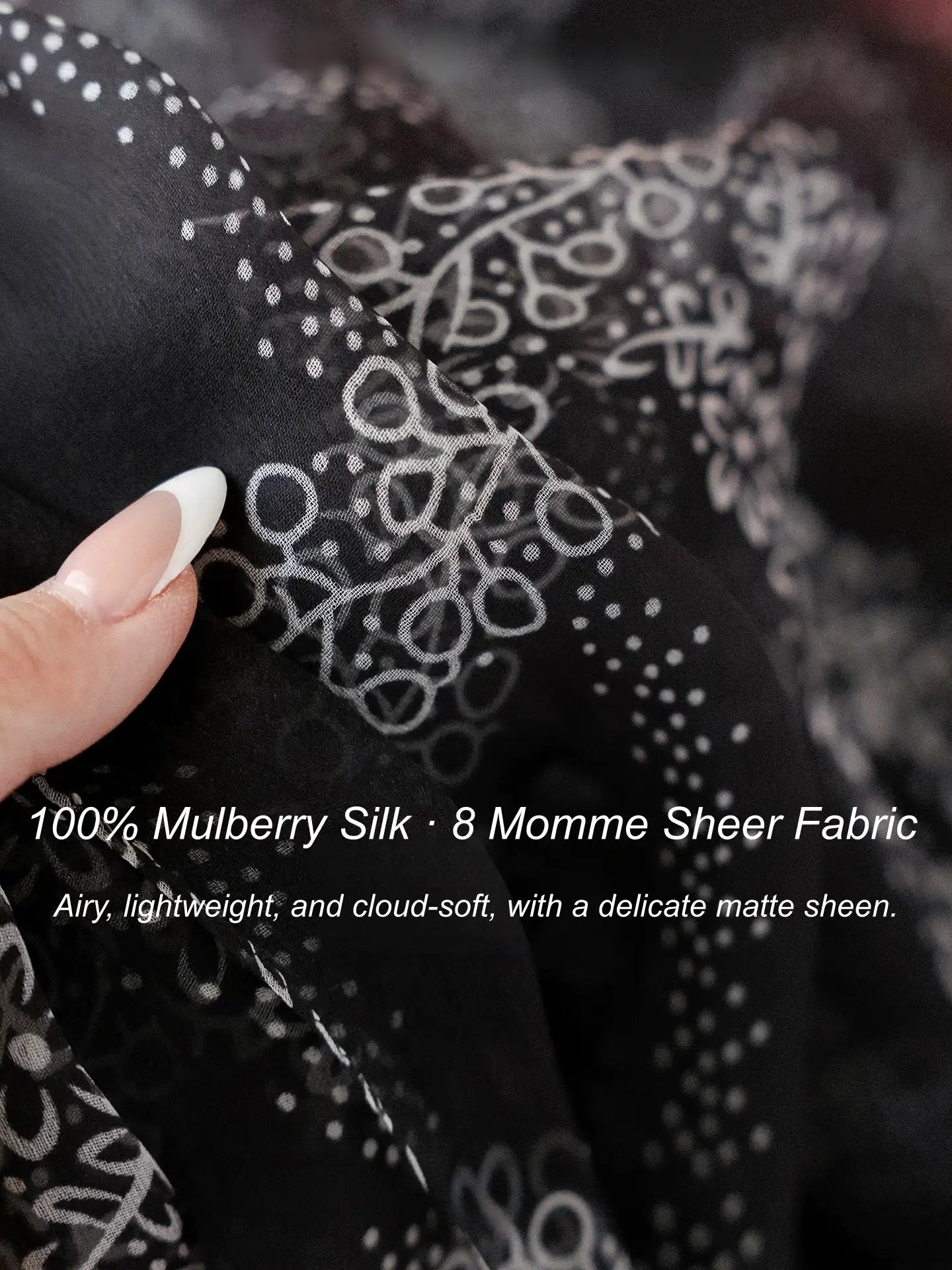 Close-up of 8 momme black mulberry silk chiffon with a delicate white floral print