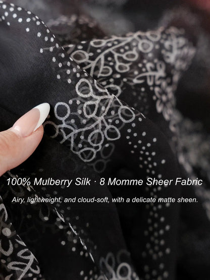 Close-up of 8 momme black mulberry silk chiffon with a delicate white floral print