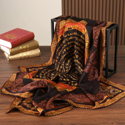 Black gold Xiangyun silk scarf draped beside vintage books to display its large square shape