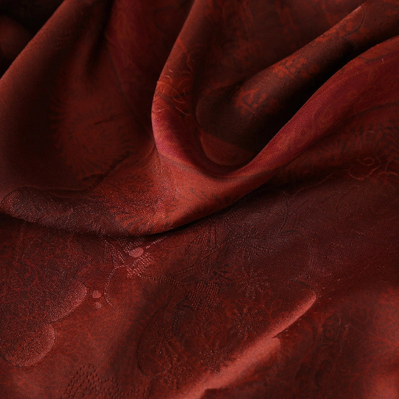 Close-up of the deep burgundy texture and subtle sheen of traditional Xiangyun silk