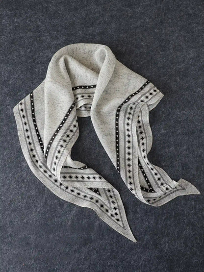 Black and gray geometric silk wool scarf arranged to show its tapered diamond shape