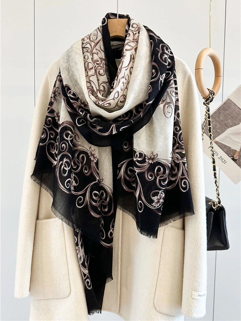 Black and ivory Baroque wool scarf looped loosely over an ivory coat with patterned ends