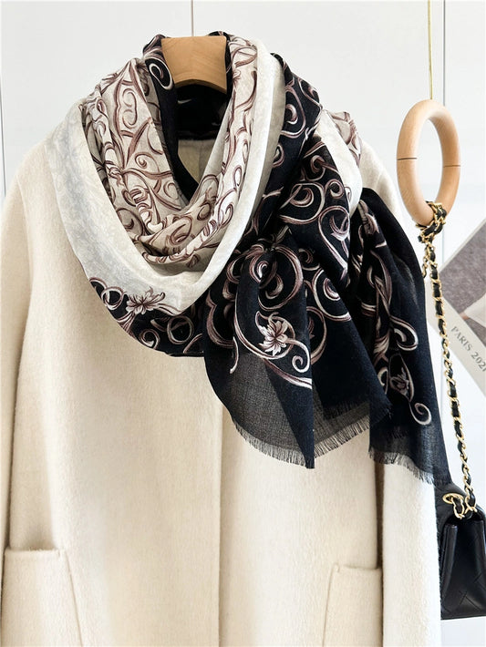 Oversized Baroque swirl wool scarf draped asymmetrically over an ivory coat