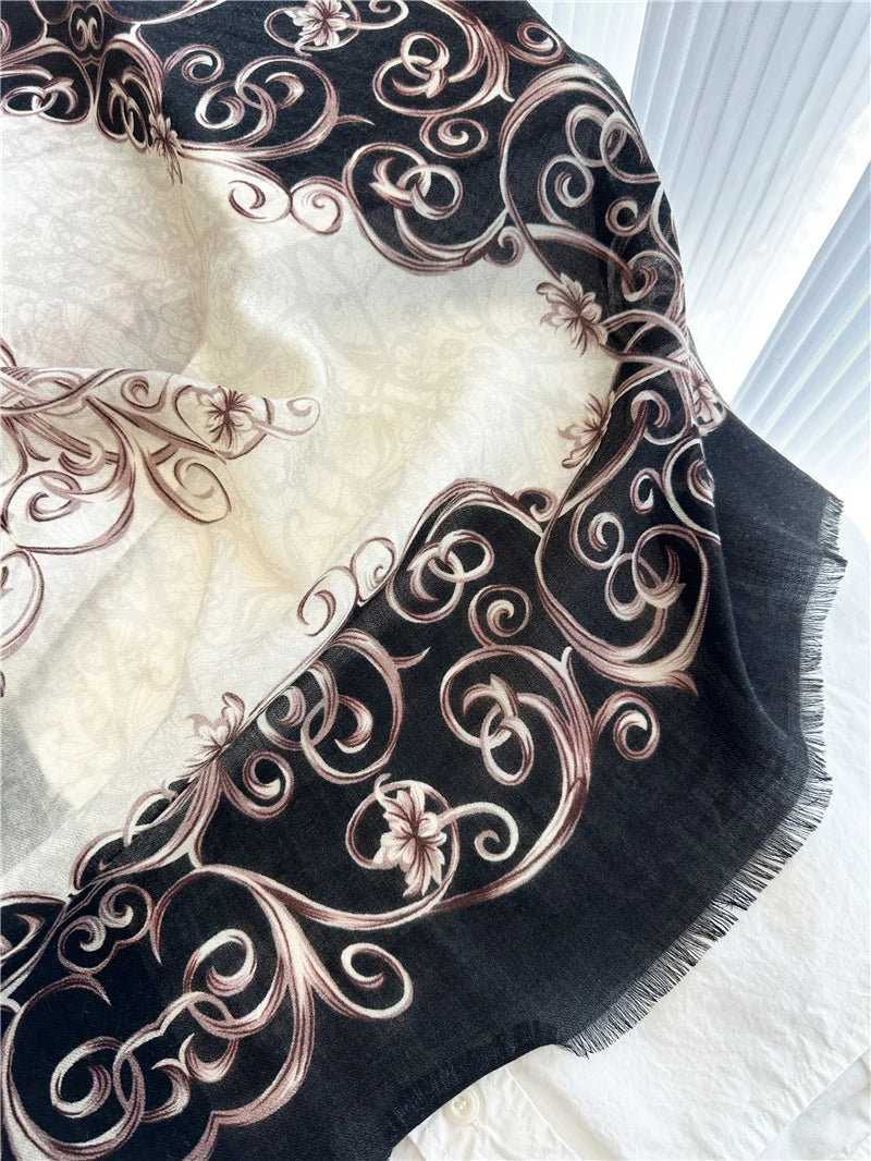 Close-up of ivory and black Baroque scroll print with delicate fringe on the wool scarf