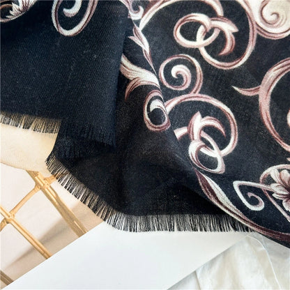 Close-up of the black Baroque scroll border and fine fringe on the wool scarf