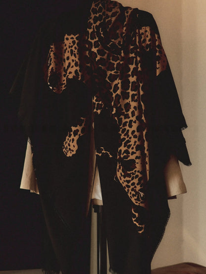 Oversized black leopard graphic wool shawl draped over the shoulders with an elegant monochrome outfit
