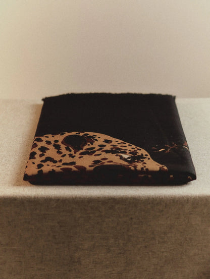 Folded black leopard print wool scarf showing its lightweight texture and oversized animal graphic