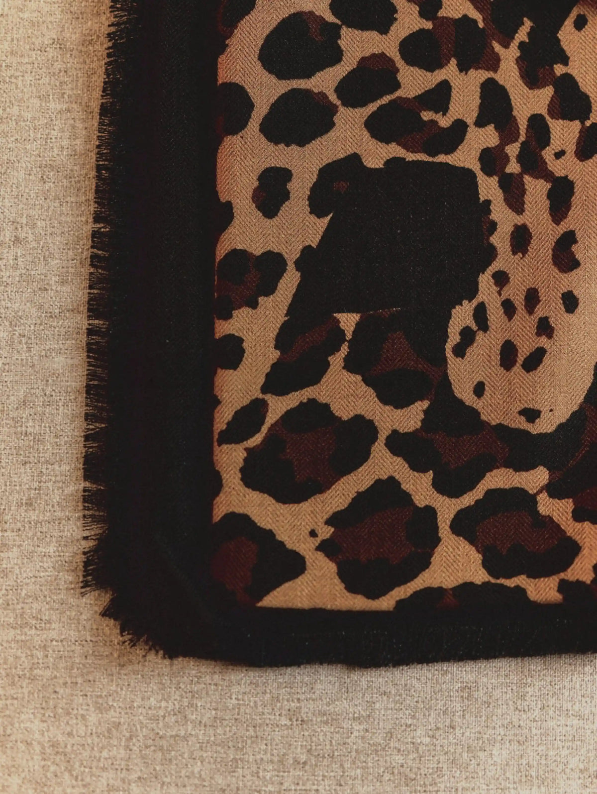 Detailed leopard face and spotted pattern on an oversized black wool scarf