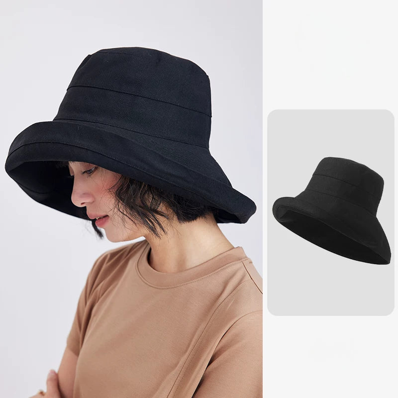 Woman wearing a black linen blend wide brim sun hat with a softly structured bucket silhouette
