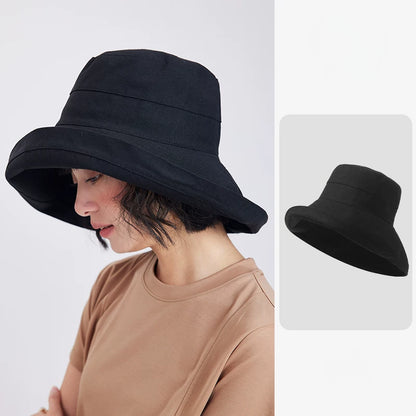 Woman wearing a black linen blend wide brim sun hat with a softly structured bucket silhouette