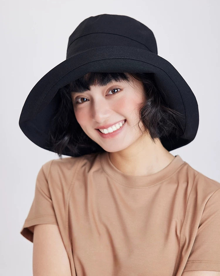 Front view of a black linen cotton wide brim sun hat styled for minimalist summer outfits