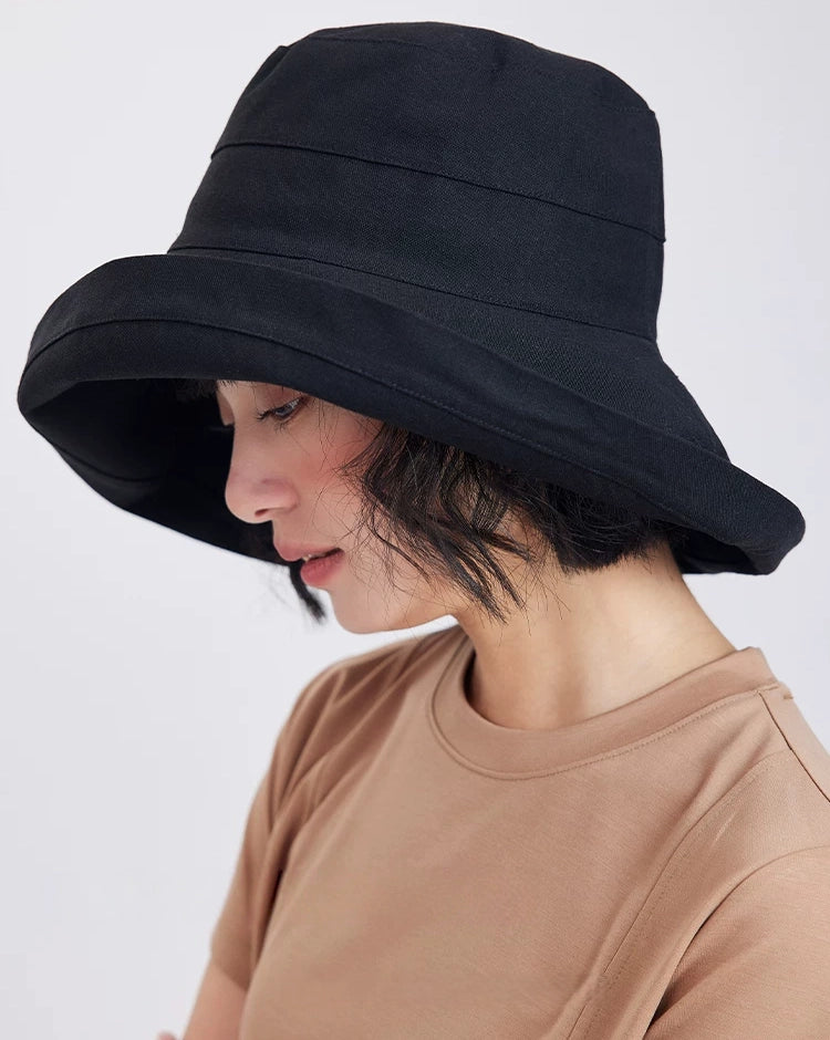 Side view of a black packable sun hat with a flexible wrap-around brim