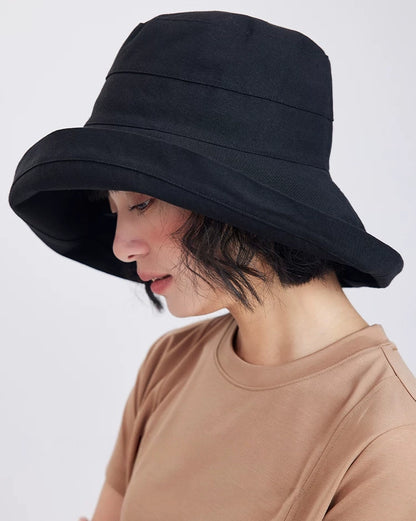 Side view of a black packable sun hat with a flexible wrap-around brim