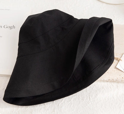 Close-up of a foldable black linen cotton sun hat showing its soft brim and fabric texture