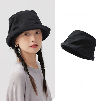 Black crinkled linen bucket hat with rolled short brim, shown on model with product view