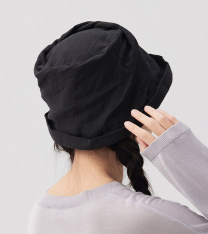 Back view of black crinkled linen bucket hat with soft foldable shape and adjustable fit