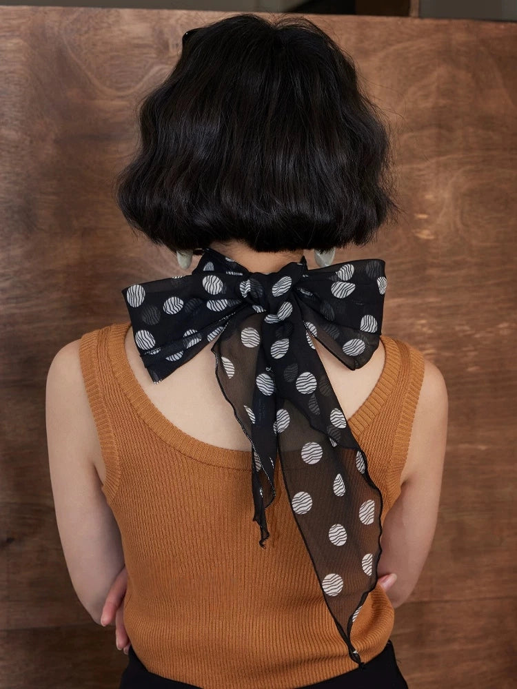 Black polka dot skinny silk scarf styled as a hair ribbon bow, 100% mulberry silk georgette