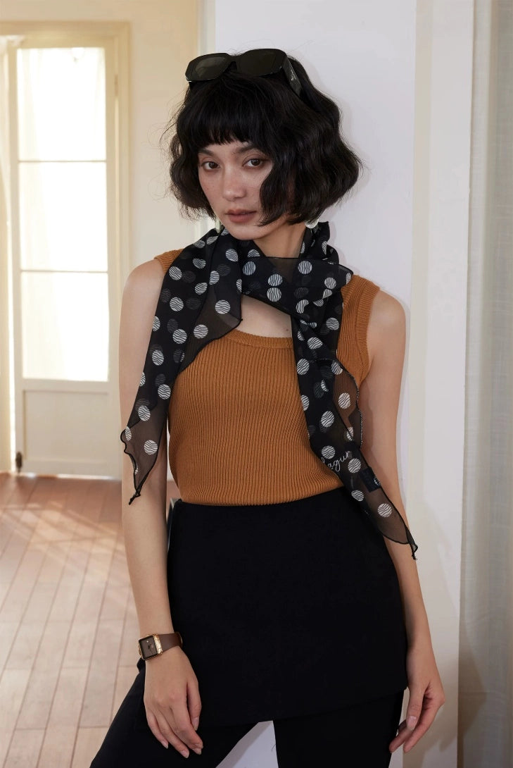 Elegant black polka dot skinny silk scarf styled with sleeveless top for French-inspired daily wear