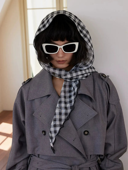 Black white gingham silk head scarf styled with trench coat and sunglasses for chic travel wear